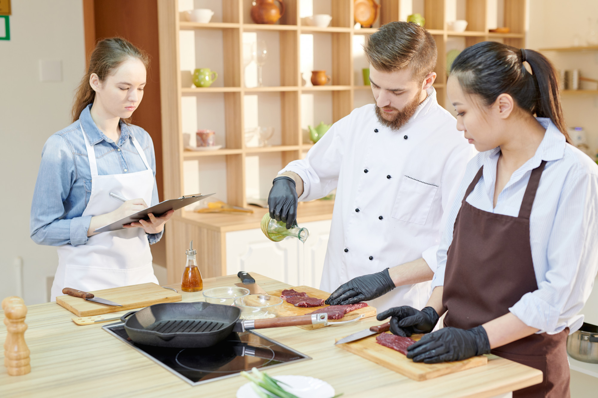 consultant demonstrating plating to small kitchen team